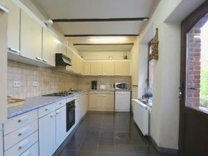 a large kitchen with white cabinets and appliances at Welcoming Mansion with Sauna in Herbeumont in Herbeumont