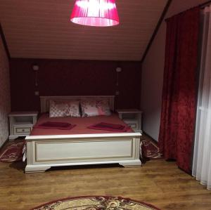 ein Schlafzimmer mit einem großen Bett mit rosa Licht in der Unterkunft Садиба Вікторія in Morschyn