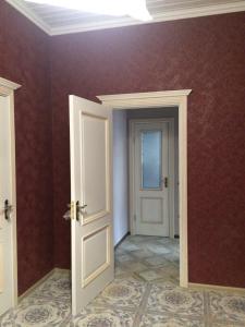 Habitación vacía con puerta blanca y paredes rojas en Садиба Вікторія, en Morshyn