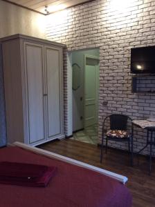 ein Wohnzimmer mit einem weißen Schrank und einer Ziegelwand in der Unterkunft Садиба Вікторія in Morschyn