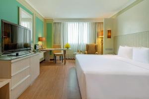 a hotel room with a large bed and a television at Windsor Plaza Hotel in Ho Chi Minh City