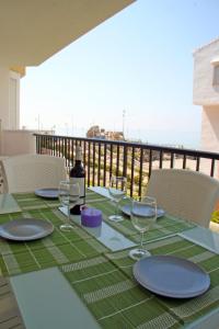 - une table avec des assiettes et des verres à vin sur un balcon dans l'établissement First Line Beach Apartment with Two Bedrooms and Sea View, à Nerja
