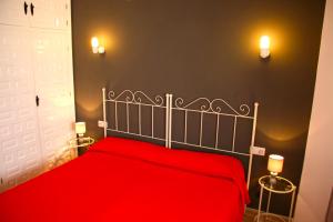 Un dormitorio con una cama roja con dos luces. en First Line Beach Apartment with Two Bedrooms and Sea View, en Nerja