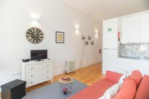 ポルトにあるSmooth Oporto Apartment by Porto City Hostsのリビングルーム(赤いソファ、壁掛け時計付)