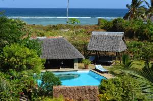 een resort met een zwembad en de oceaan bij Coast Sun Gardens Cottage in Msambweni