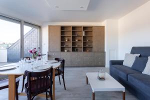 a living room with a table and a couch at Le Mancini - Parking et Terrasse in Mayenne