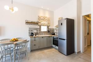 a kitchen with a stainless steel refrigerator and a table at Panorama Luxury Rooms in Spílion