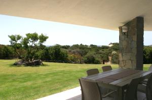 a patio with a table and chairs and a field at Casa Bithia in Chia