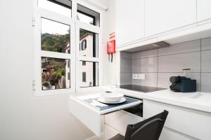 a white kitchen with a table and a window at Villa Ponta do Sol Apartment in Ponta do Sol