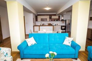 un sofá azul en una sala de estar con cocina en Old City Square Apartment, en Lovech