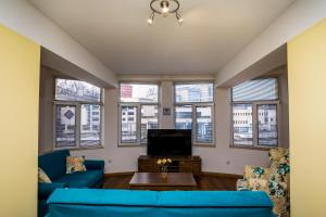 a living room with blue couches and a tv at Old City Square Apartment in Lovech