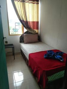 a small bedroom with a bed with a blue bow on it at Dasi Guesthouse in Ende