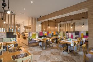 Marina White Sands Beach Hotel-All Inclusive في ابزور: مطعم بطاولات وكراسي خشبية في الغرفة