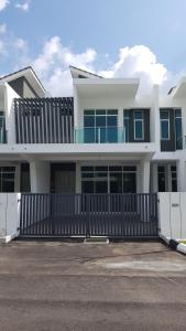 a large white house with a black fence at langkawi homestay murah empat bilik in Kuah