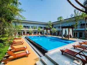 a pool with lounge chairs and a hotel at Bora Bora Villa Phuket in Chalong