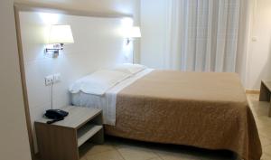 a hotel room with a bed and a phone on a table at Hotel Victoria in Torre Santa Sabina