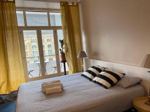 ein Schlafzimmer mit einem Bett mit zwei Kissen und einem Fenster in der Unterkunft Kasa Reina HT LSS00215 in San Sebastián