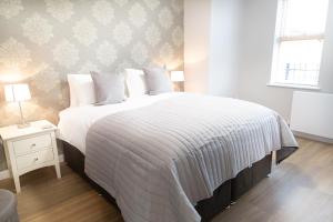 a bedroom with a large bed with a white comforter at Citystay - Hinton House in Cambridge