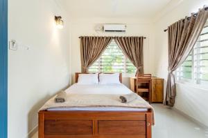 a bedroom with a bed and a window at Poetrie Homestay in Ernakulam