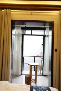 西安市にあるEastwood Inn Xi'anの窓、テーブル、ベッドが備わる客室です。