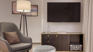 
a living room filled with furniture and a tv at Bilderberg Bellevue Hotel Dresden in Dresden

