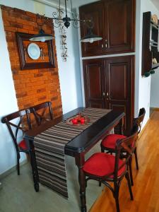 a dining room table with chairs and a brick wall at 5 Star Residence in Braşov