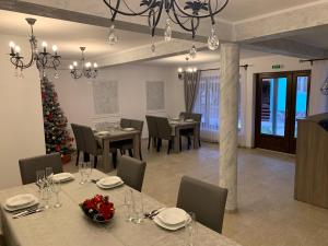 a dining room with tables and chairs and a christmas tree at Casa La Bella Vista in Moisei
