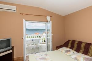 a living room with a tv and a sliding glass door at Apartments Golubić in Sveti Petar