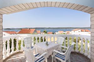 a table and chairs on a balcony with a view of the ocean at Apartments Golubić in Sveti Petar