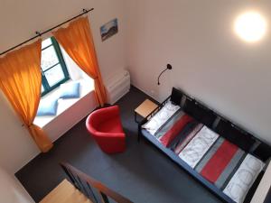 una vista aérea de una habitación con 2 camas y una silla roja en Wellness hotel Lihovar en Třemošnice