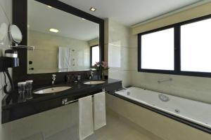a bathroom with two sinks and a bathtub at Hotel Cordoba Center in Córdoba