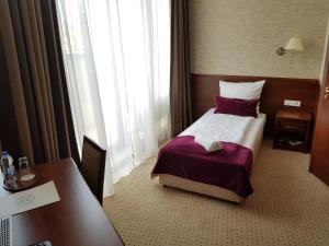 Un pat sau paturi într-o cameră la Hotel Starzyński