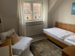 mały pokój z łóżkiem i oknem w obiekcie Lindenhof w mieście Hainburg