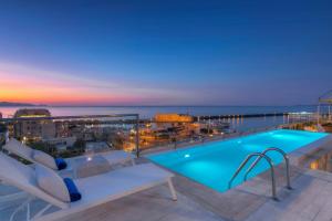 a pool on the roof of a building with the ocean at GDM Megaron, Historical Monument Hotel in Heraklio