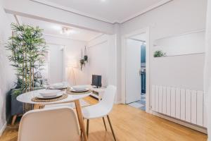a white living room with a table and chairs at Mizar Apartment by People Rentals in Bilbao