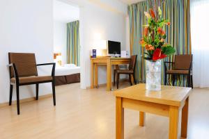 a living room with a vase of flowers on a table at Residhome Paris-Massy in Massy
