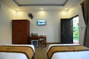 a hotel room with two beds and a table at Đồi Sao Phú Quốc in Phu Quoc