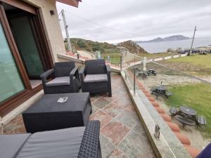 eine Terrasse mit 2 Stühlen und einem Tisch auf dem Balkon in der Unterkunft Caracola de Cabo Home in Hio