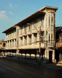 een oud houten gebouw aan de straatkant bij The Mustang Blu in Bangkok