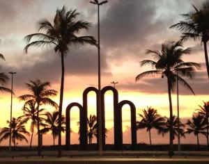 un grupo de palmeras frente a una puesta de sol en Aracaju Temporada, en Aracaju