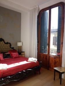 1 dormitorio con cama roja y ventana grande en Gelsomino 74, en Florencia