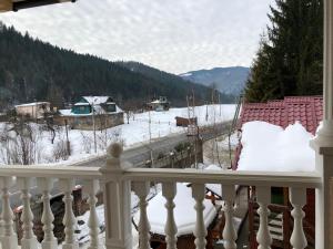 un balcón nevado con vistas a un patio cubierto de nieve en Complex Svitanok, en Yaremche