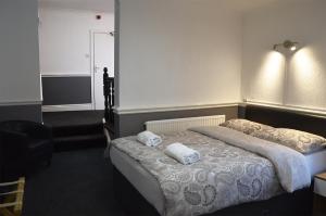 ein Schlafzimmer mit einem Bett mit Handtüchern darauf in der Unterkunft The Gurkha Hotel in Blackpool