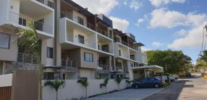 a building with a car parked in a parking lot at Westwood Luxury Penthouse with private Roof top Ref 15847 in Flic-en-Flac