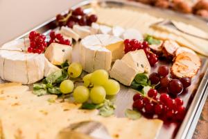 a plate of food with cheese and grapes and meat at Haus am Parc in Meppen