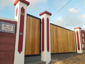 カリェタにあるthe old schoolの建物の隣の赤と白の柱の柵
