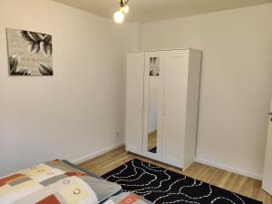 ein Schlafzimmer mit einem Spiegel und einem Bett darin in der Unterkunft Moderne Neubau Ferienwohnung in Wiesbaden