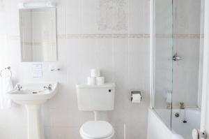 a bathroom with a toilet and a sink and a shower at The Gurkha Hotel in Blackpool +26 photos