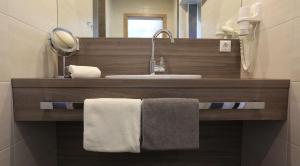 a bathroom with a sink and a mirror and towels at Ferienweingut Pies Ellenz-Poltersdorf in Ellenz-Poltersdorf