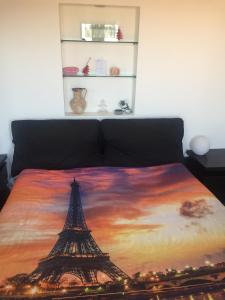 a bed with a painting of the eiffel tower at Alloggio Turistico Roberta San Pietro in Rome